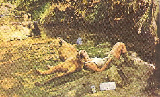 Joy Adamson resting on Elsa the Lion by her favorite river